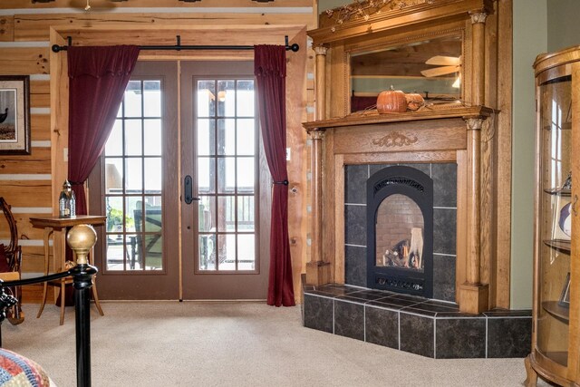 entryway featuring carpet floors, a fireplace, and french doors