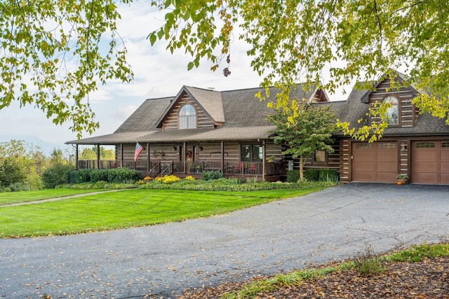 log-style house with a porch, a garage, and a front lawn