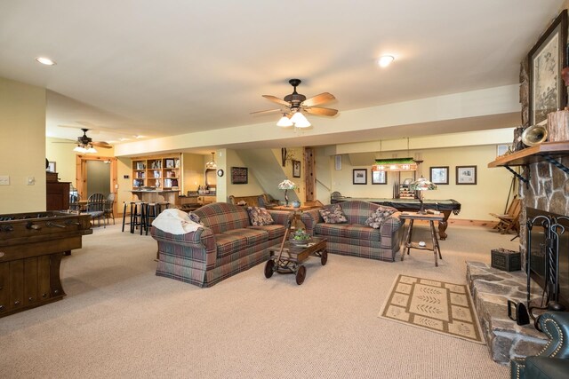 carpeted living room with a fireplace and ceiling fan