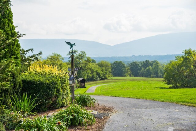 view of home's community with a mountain view and a lawn