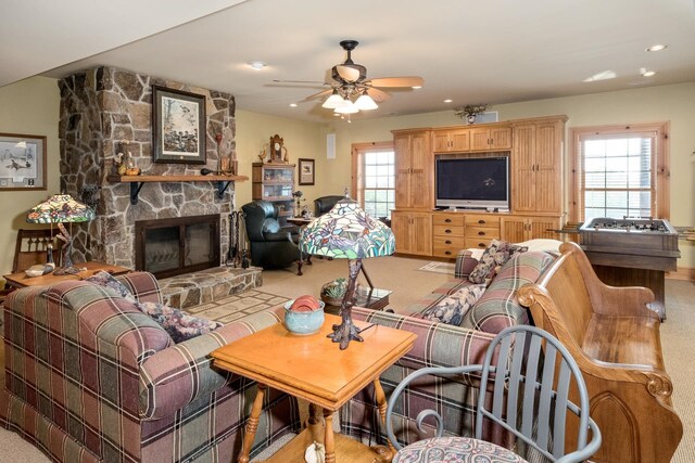 carpeted living room featuring ceiling fan and a fireplace