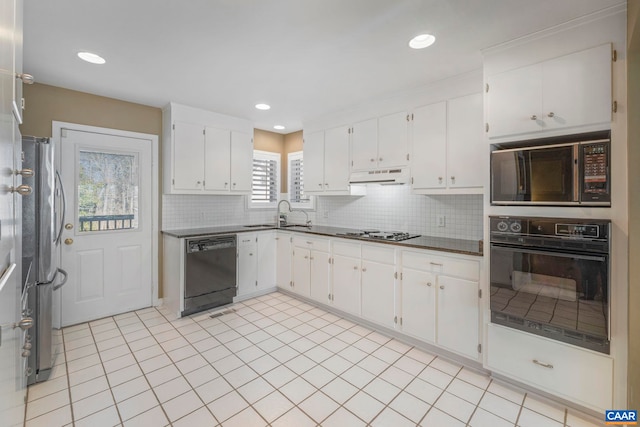 kitchen featuring backsplash, white cabinets, a sink, under cabinet range hood, and black appliances