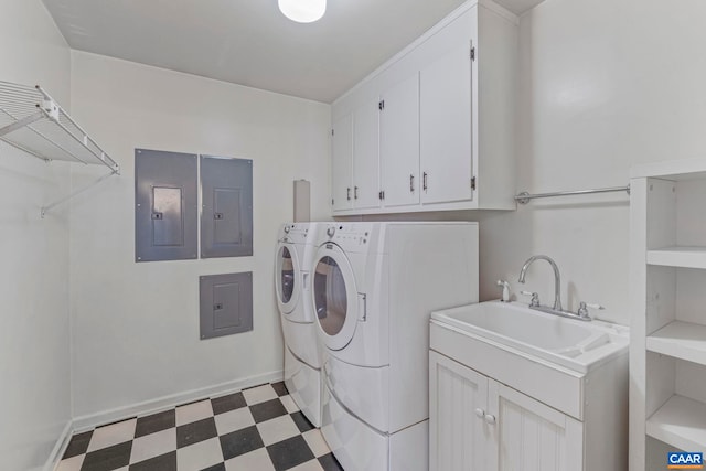 laundry room featuring washing machine and dryer, electric panel, a sink, and light floors