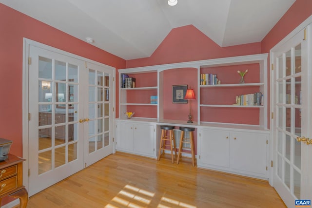 interior space featuring french doors, vaulted ceiling, and light wood-style flooring