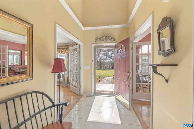 foyer with crown molding, baseboards, and light tile patterned floors