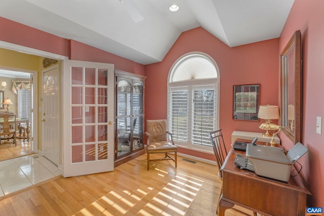 home office with visible vents, vaulted ceiling, and wood finished floors