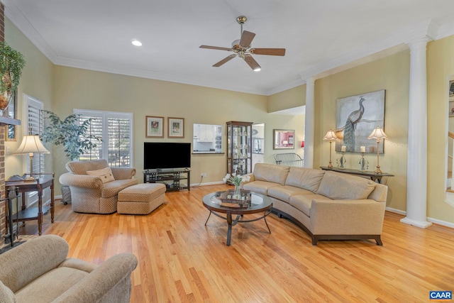 living room featuring crown molding, decorative columns, baseboards, and wood finished floors