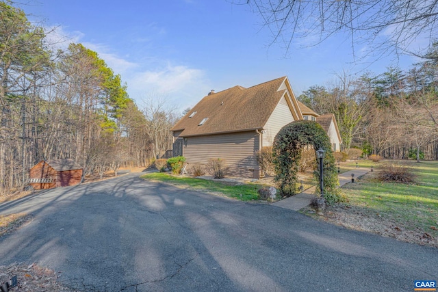 view of property exterior with a shingled roof and a chimney