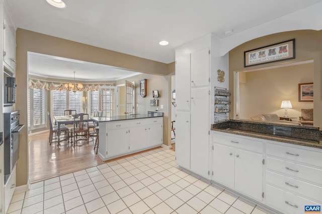 kitchen featuring white cabinets, a peninsula, light tile patterned flooring, a notable chandelier, and recessed lighting