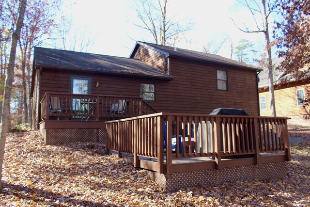 rear view of house featuring a wooden deck