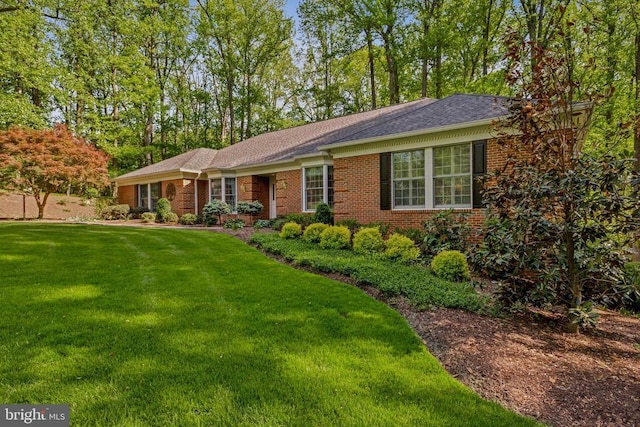 single story home featuring brick siding and a front yard