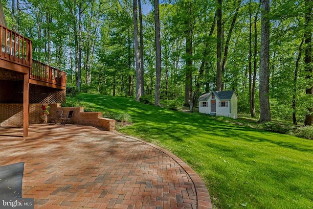 view of yard with a wooden deck, a patio, and an outdoor structure