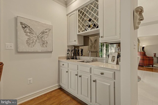 living room featuring ornamental molding, built in features, wood finished floors, a fireplace, and a ceiling fan