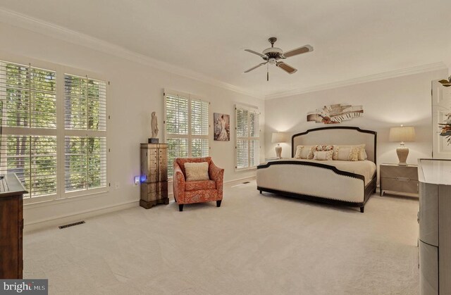 carpeted bedroom featuring visible vents, ornamental molding, baseboards, and ceiling fan
