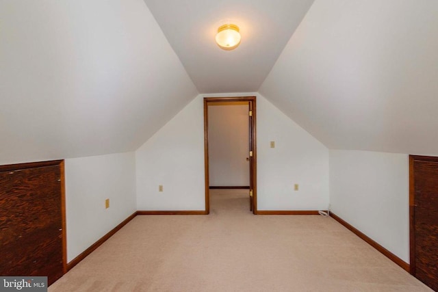 bonus room featuring vaulted ceiling and light colored carpet