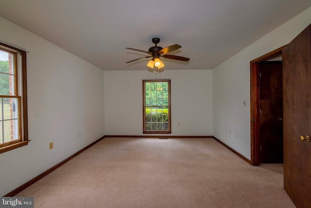 carpeted spare room featuring ceiling fan