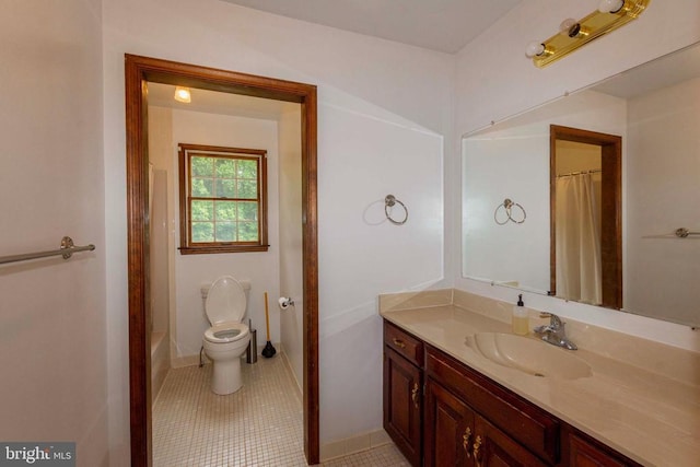 bathroom featuring vanity, tile patterned floors, and toilet