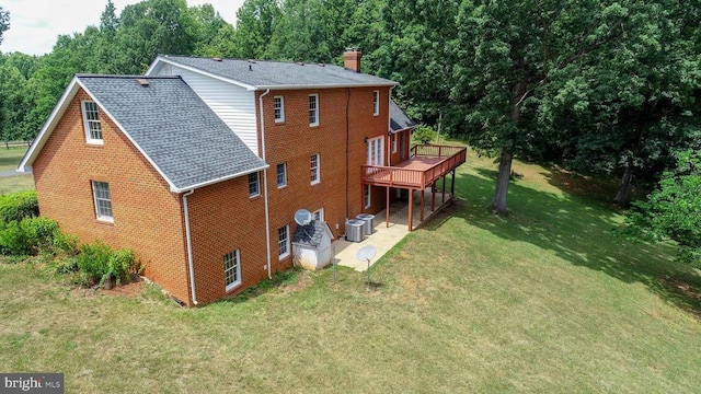 rear view of property featuring a wooden deck, a lawn, and central air condition unit