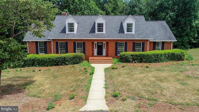 cape cod home with a front lawn