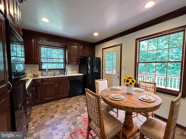 kitchen featuring dark brown cabinets, sink, backsplash, and black appliances