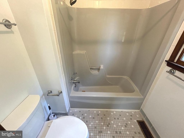 bathroom with tile patterned floors, bathing tub / shower combination, and toilet