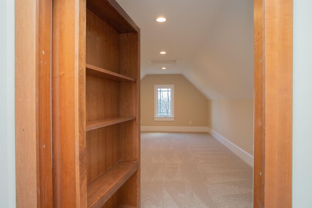 bonus room with lofted ceiling and light carpet