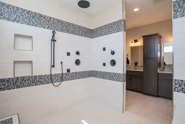 bathroom featuring vanity, a tile shower, and tile patterned floors