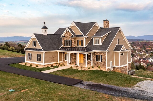 craftsman-style house featuring a mountain view, a front yard, and a porch