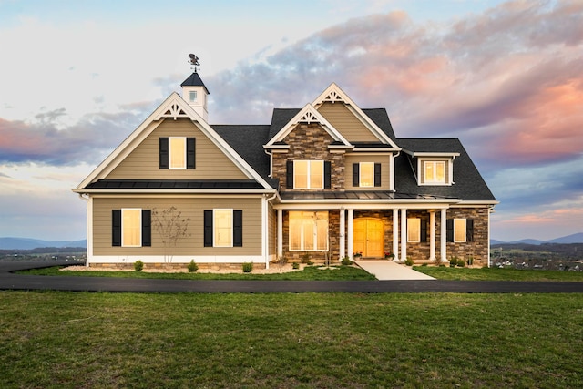 craftsman-style home with a mountain view, a yard, and covered porch