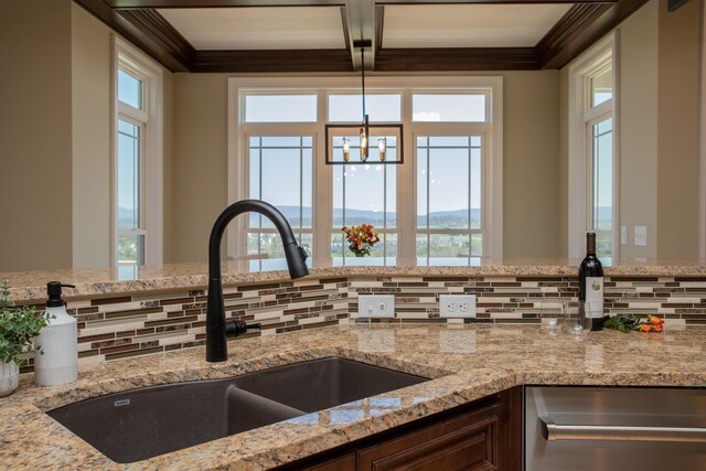 kitchen with sink, pendant lighting, beam ceiling, light stone countertops, and decorative backsplash