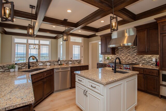 kitchen with decorative light fixtures, white cabinetry, dishwasher, sink, and wall chimney range hood