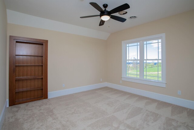 carpeted spare room featuring ceiling fan and lofted ceiling