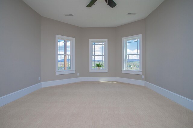 unfurnished room featuring light colored carpet and ceiling fan