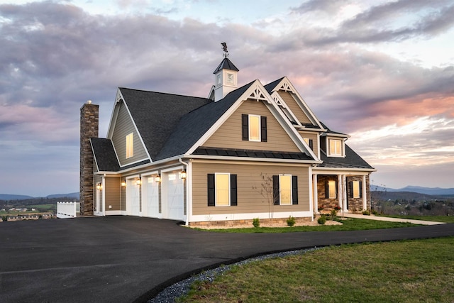 view of front of property with a mountain view, a garage, and a lawn