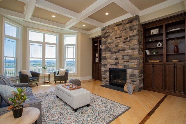 living room featuring beamed ceiling, light hardwood / wood-style floors, and a healthy amount of sunlight