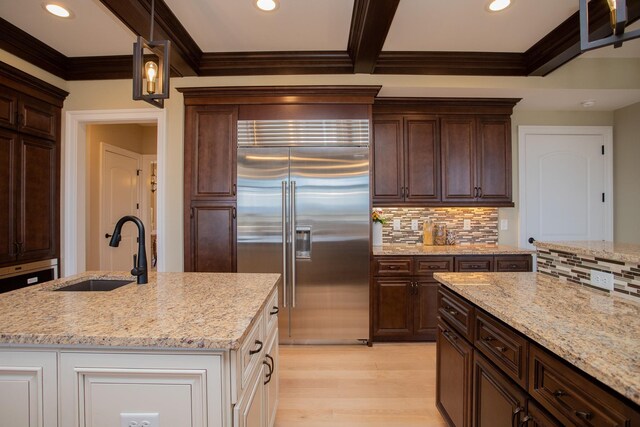 kitchen with light stone countertops and stainless steel built in refrigerator