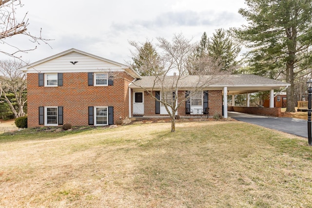 tri-level home featuring a front yard, aphalt driveway, an attached carport, and brick siding