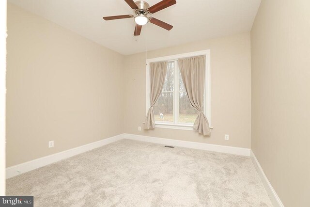 carpeted spare room featuring ceiling fan