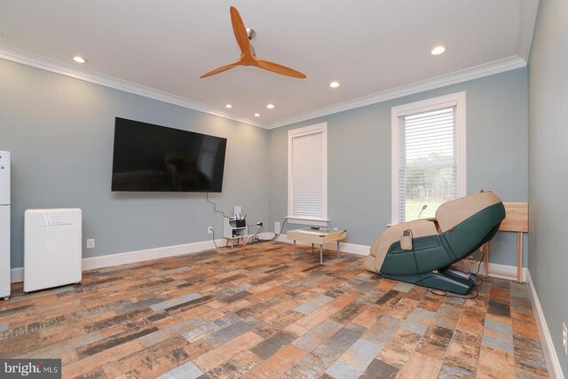 sitting room with wood-type flooring, ornamental molding, and ceiling fan