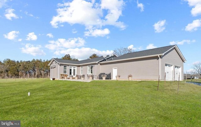 rear view of property featuring a yard and a garage