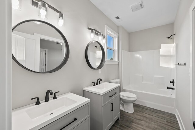 full bathroom with vanity, wood-type flooring, bathing tub / shower combination, and toilet