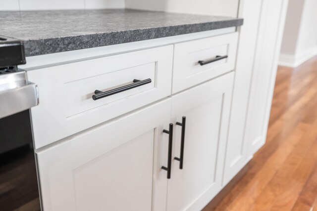 details with white cabinetry and light hardwood / wood-style floors