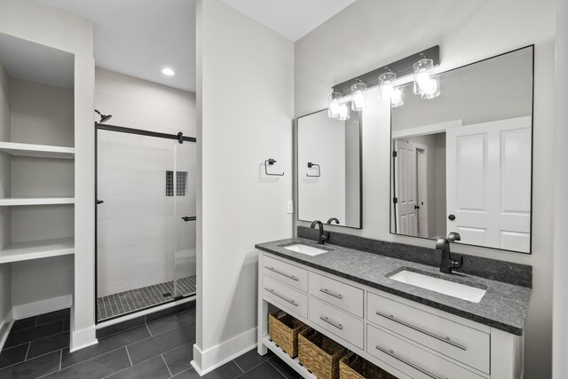 bathroom featuring a shower with door, vanity, and tile patterned flooring