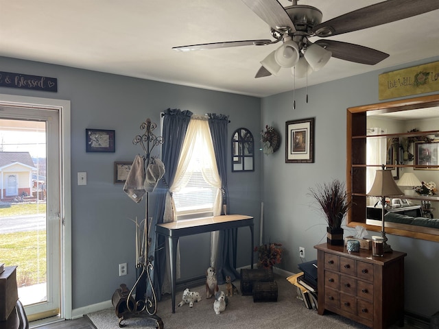 interior space with a ceiling fan and baseboards