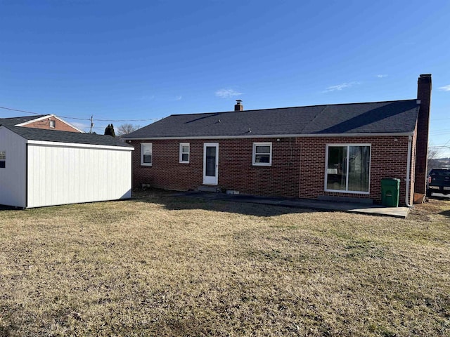 back of property featuring an outbuilding, brick siding, a lawn, a shed, and a chimney