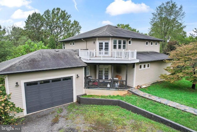 view of front of property with a garage, driveway, french doors, and roof with shingles