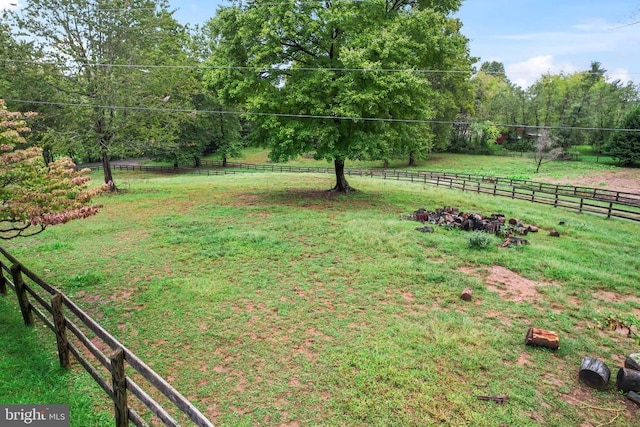 view of yard with fence and a rural view