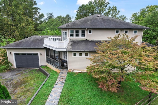 rear view of house with a garage, roof with shingles, driveway, and a balcony