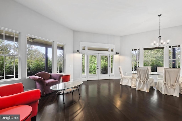 living area with french doors, wood finished floors, and a notable chandelier