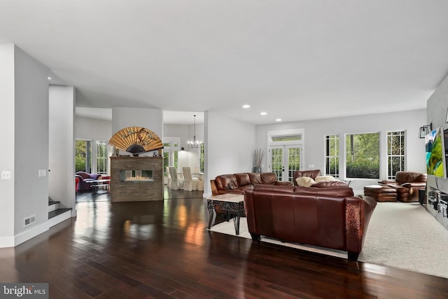 living room with french doors, recessed lighting, a glass covered fireplace, wood finished floors, and baseboards